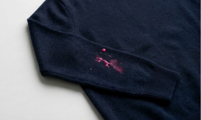 donkerblauwe trui met spetters roze nagellak op de mouw