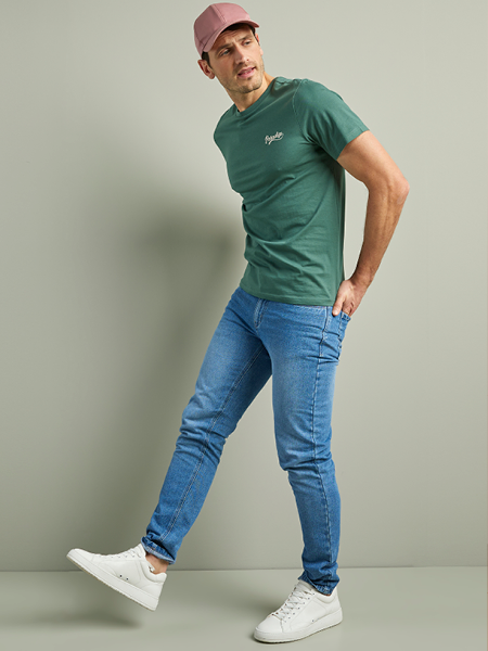man in een donkere heren jeans en een groen t-shirt