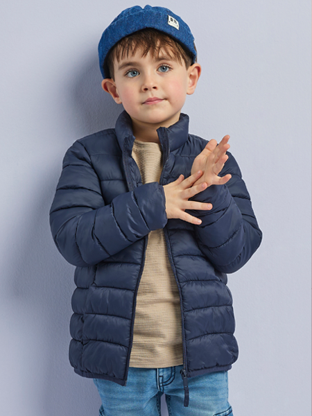 jongen met een blauwe gewatteerde jas