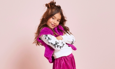 meisje met paarse broek, witte top en paars gilet