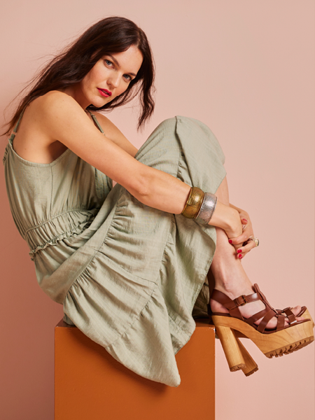 vrouw zittend op een blok in een groene midi jurk