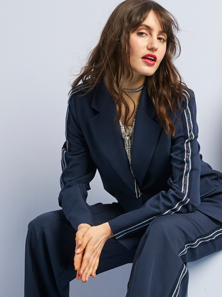 vrouw in een navy pak met streep op mouwen