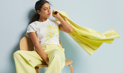 vrouw met een geel polyester pak en wit polyester t-shirt