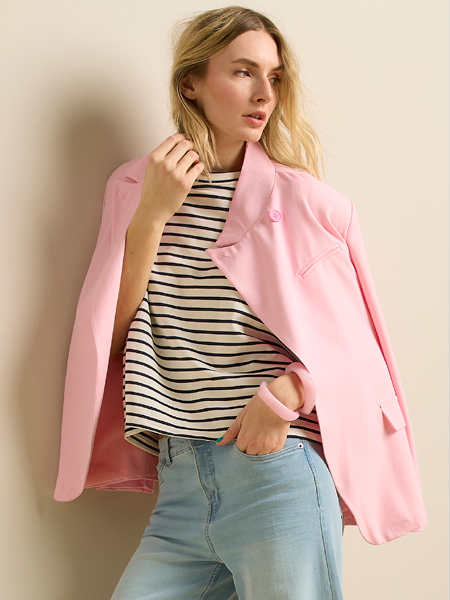vrouw met roze blazer met daaronder gestreept t-shirt
