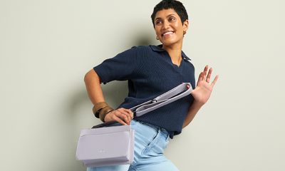 een vrouw met een grijze tas en een casual outfit