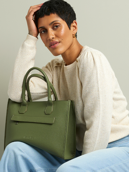 vrouw met een groene tas en casual outfit