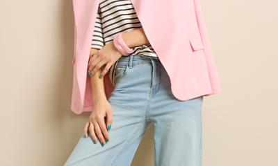 vrouw met een lichtblauwe jeans, roze blazer en streepjes t-shirt